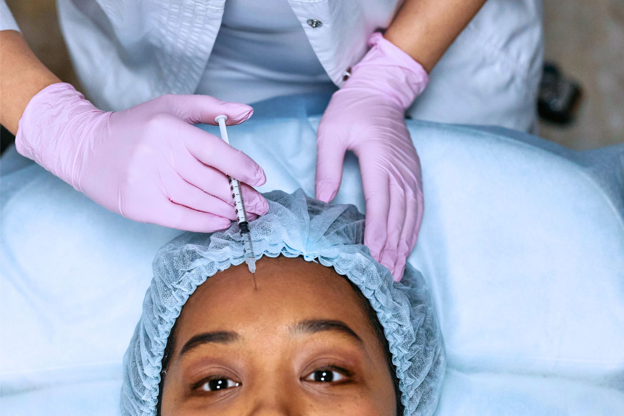 A brown woman getting forehead filler